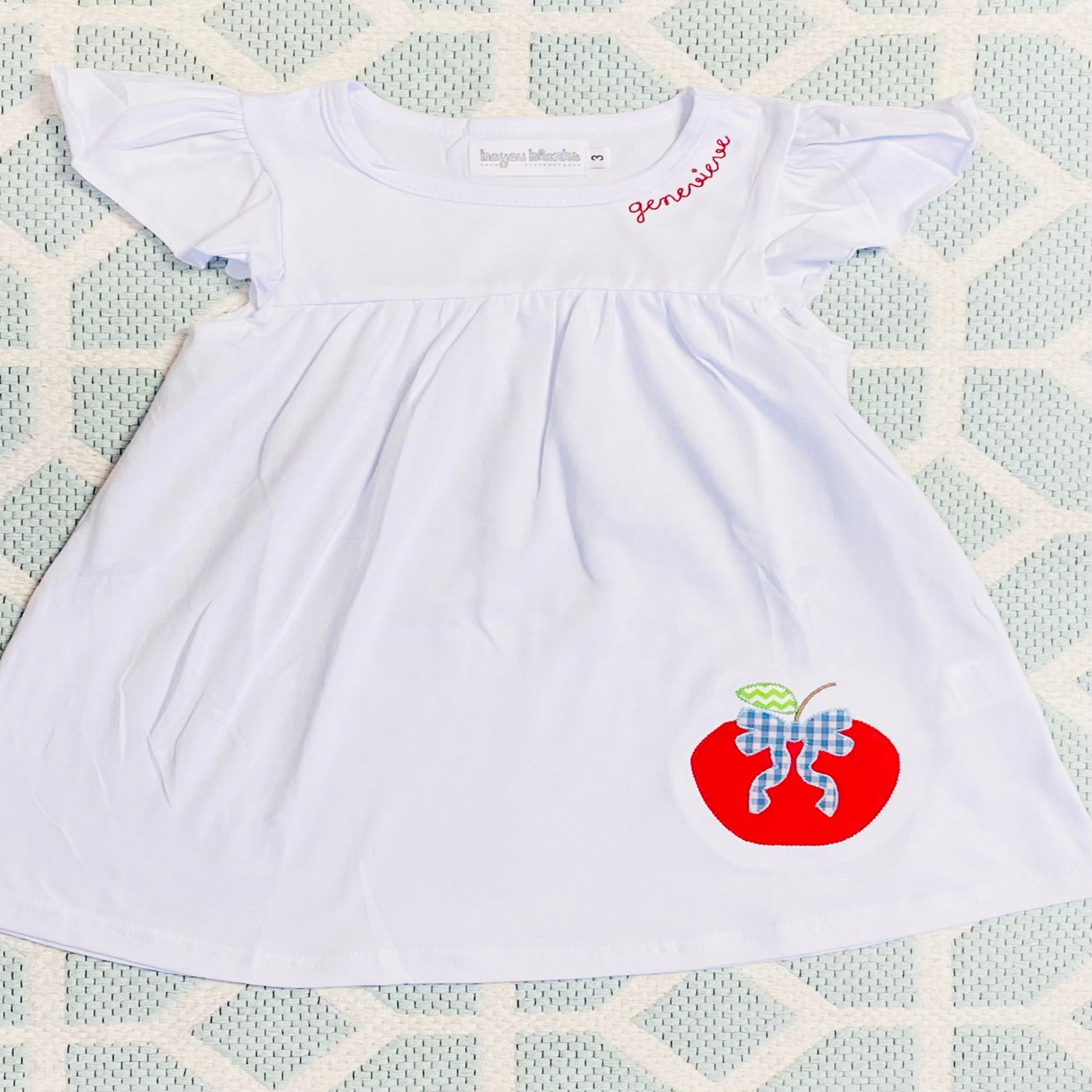 White flutter sleeve dress with apple appliqué